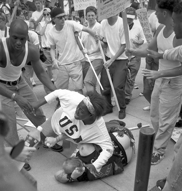 axcabal's tweet image. It's crazy how time is cyclical. Nazi Jake Lang was protected and escorted to safety by a black man, and that reminded me of another event. Different times, same vibe.