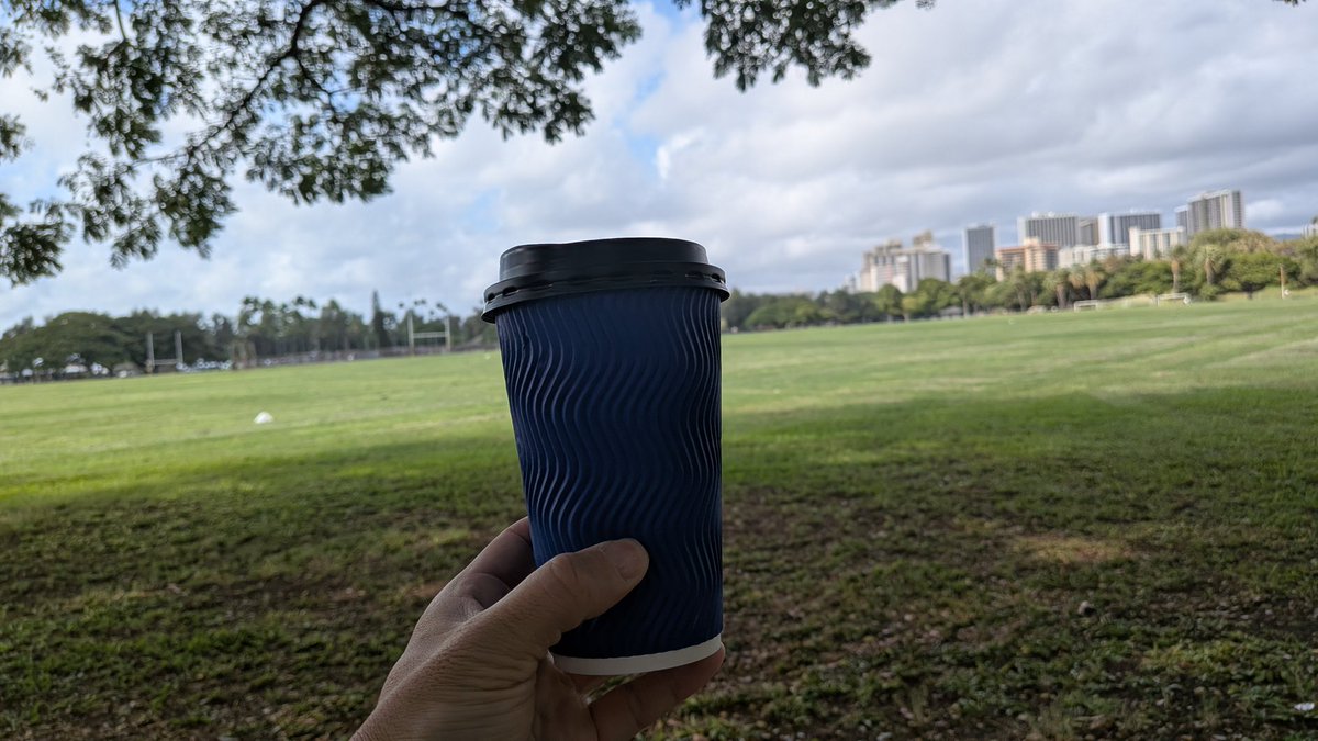 木陰で一息。目の前は芝生がどーん、奥に街。ハワイってこの距離感がいい。カップ片手にぼーっとしてるだけで、頭の中のタブが勝手に閉じていく感じ。