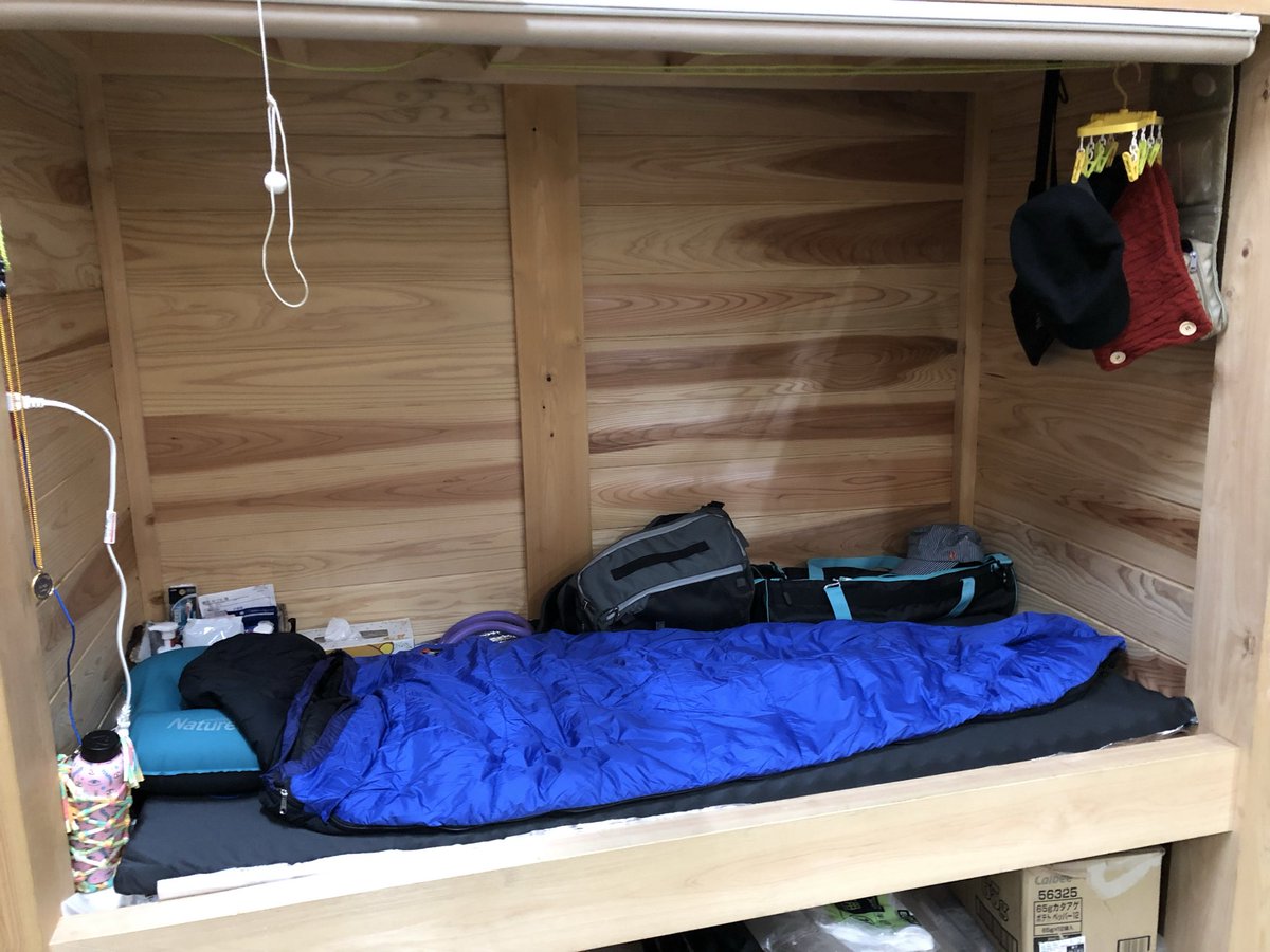 【富士山頂上での生活】
私のスペースです！厨房にある棚が私の部屋です。一畳ほどのスペースに寝袋敷いて寝ています。空いているところにカメラや生活用品を置いています。普段はロールカーテンで隠しています。
洗濯をした時はこの中に干しています。（私以外男性しかいないので）
