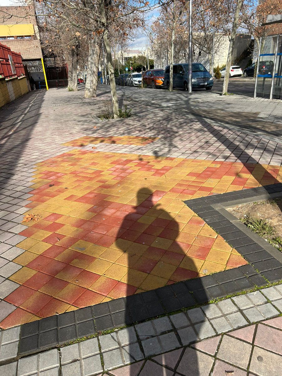 En Puente de Vallecas no se tiran baldosas: se hace patchwork urbano. Si faltan de un color, se pone lo que haya, que el arte es libre. Las antiguas quizá eran como las nuevas, pero ahora son más grises, y habría quedado demasiado bien. Javier de Miguel con Puerto de los Milagros