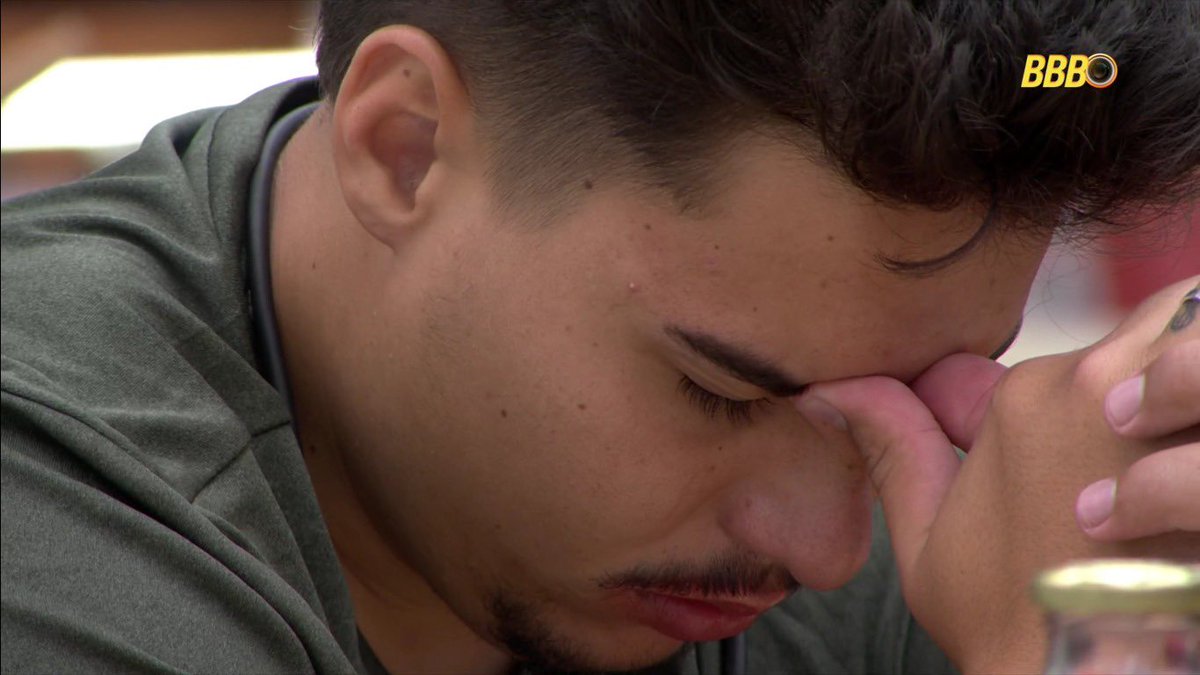 poponze's tweet image. Pedro se isolou na mesa e está batendo a perna enquanto fica com a cabeça abaixada. #BBB26