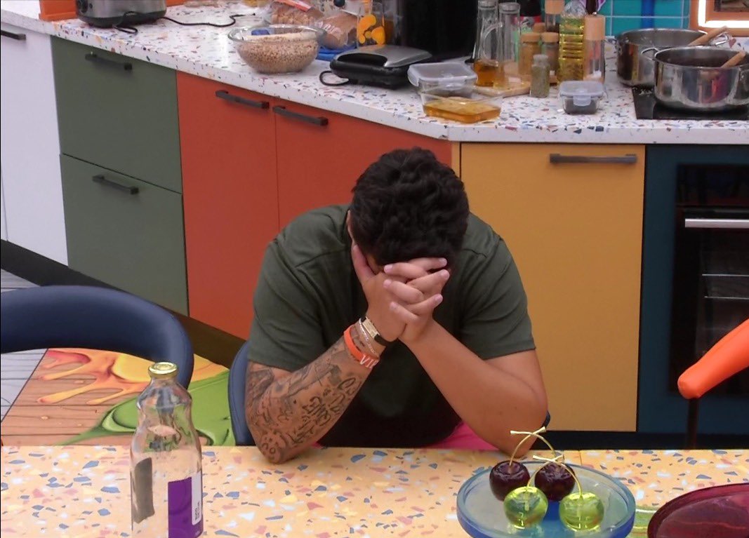 poponze's tweet image. Pedro se isolou na mesa e está batendo a perna enquanto fica com a cabeça abaixada. #BBB26