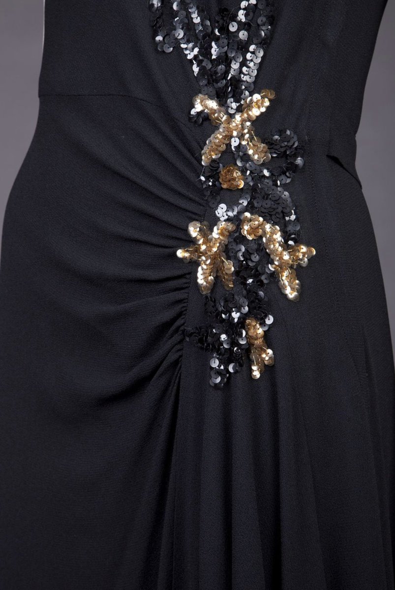 kateStrasdin's tweet image. Asymmetry beautifully executed here, taking black rayon crepe and draping it across the body at an angle, along with a sweep of metallic sequins. Mid #1940s evening wear on point #goldsteinmuseum #fashionhistory