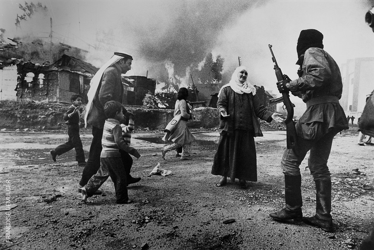 palestinian_the's tweet photo. صورة من مجزرة الكرنتينا | ١٨ يناير ١٩٧٦
بعدسة المصورة الفرنسية فرنسواز ديمولدير. 
وتعتبر هذه الصورة، التي تظهر فيها سيدة فلسطينية أمام مُسلح من ميليشيات اليمين المسيحي، وعدد من الفلسطينيين يحاولون الهرب، واحدة من أشهر صور الحرب الأهلية اللبنانية وفازت بجائزة "وورد برس" عام ١٩٧٧ 
1⃣