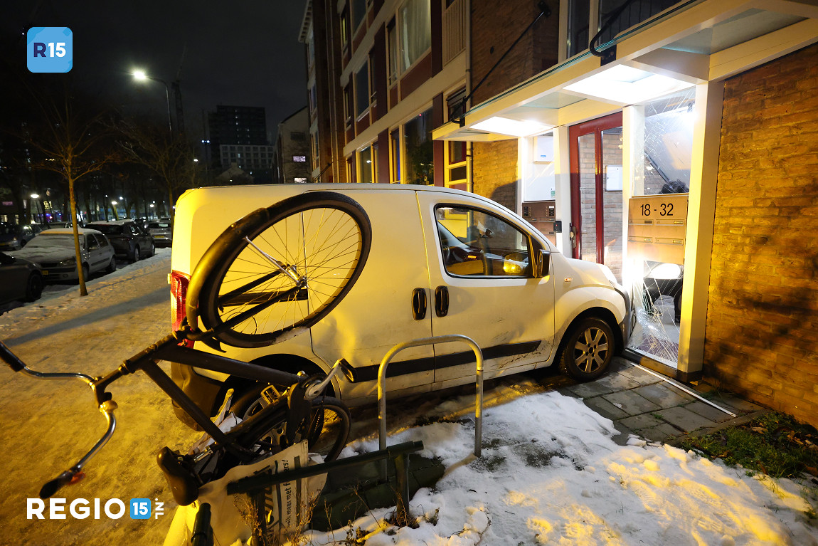 Ingesneeuwd busje komt vrij en botst tegen portiek