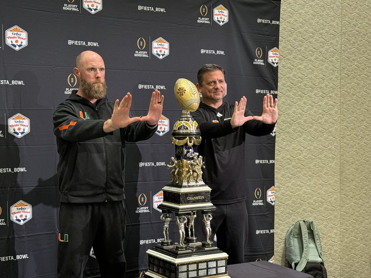 Shannon Dawson and Corey Hetherman pose with the Fiesta Bowl trophies.