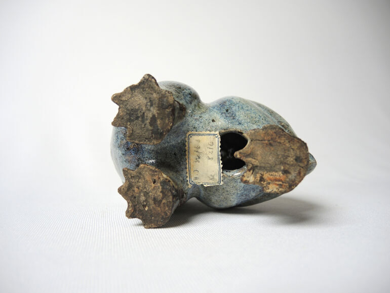 archaeologyart's tweet photo. In Chinese iconography, this figure is deeply connected to the Moon. Contrary to the Western concept of the "Man in the Moon," the ancient Chinese viewed the shadows and craters on the lunar surface as the silhouette of a giant frog. This belief stems from the story of the Goddess Chang’e, who stole the elixir of immortality and fled to the moon. According to legend, as punishment for this theft, the goddess lost her elegant form and transformed into a warty "Moon Toad," doomed to live on the moon forever.

Pay attention to the mouth of the work—it’s wide and upturned. This carries a distinct meaning. In Chinese, the word shih, which means "eclipse," shares the same root as the verb "to eat." People believed that lunar eclipses weren’t scientific phenomena, but rather the moment this celestial frog was trying to swallow the moon. During an eclipse, villagers would scare the monster by banging on tin cans, shouting, and screaming to force it to "spit the moon back out."

Finally, I’d like to talk about the piece’s construction. In contrast to the pristine whiteness of porcelain, this stoneware work perfectly captures nature’s irregular texture. The craftsman skillfully shaped the clay to mimic the frog’s moist, rough skin, applying a special glaze known as "transmutation." The transitions between the blue, gray, and earth tones are the result of uncontrolled chemistry caused by temperature fluctuations inside the kiln. This glassy layer—which thins to a milky blue over the raised bumps on its back and deepens to navy in the folds—gives the work a wet, lifelike appearance, as if it had just emerged from a muddy pond.

You can access the work from this link: https://t.co/26TWRJp9CB