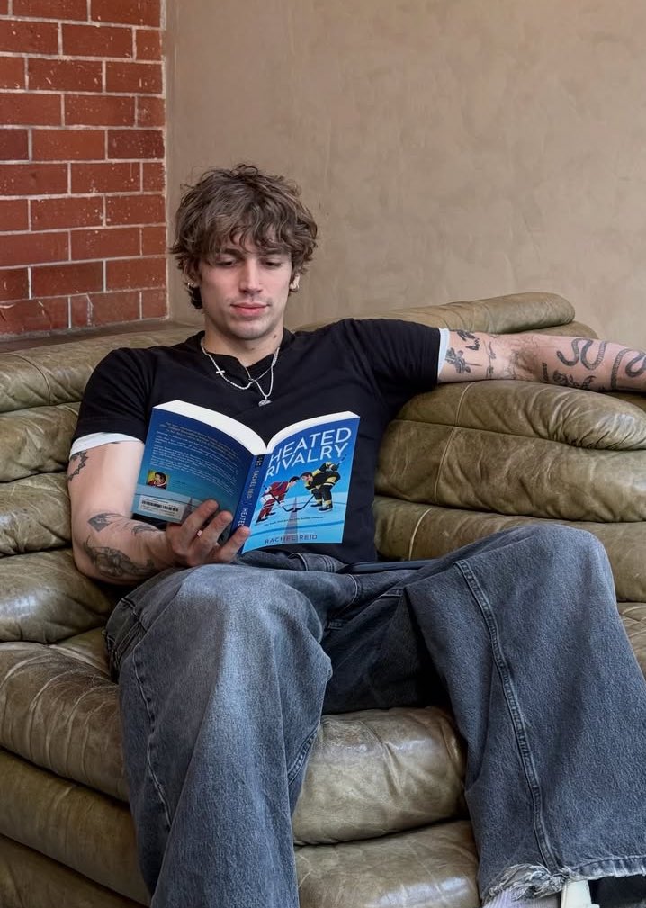 PopCrave's tweet image. Vinnie Hacker reading ‘Heated Rivalry’ in new photo.