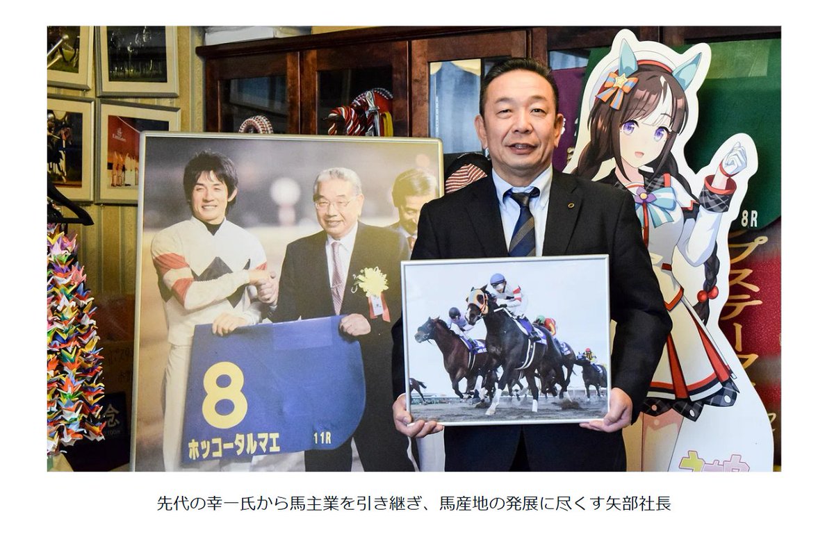 先日ポストした記事より、画像を引用させていただきます。ホッコータルマエ（実馬）の写真を持つのは「ホッコー」冠の現馬主である矢部道晃オーナー。その向かって左には、握手をする先代（道晃氏の父）の故・矢部幸一オーナーとタルマエ主戦の幸英明騎手の写真。そして、向かって右にはウマ娘のホッコ