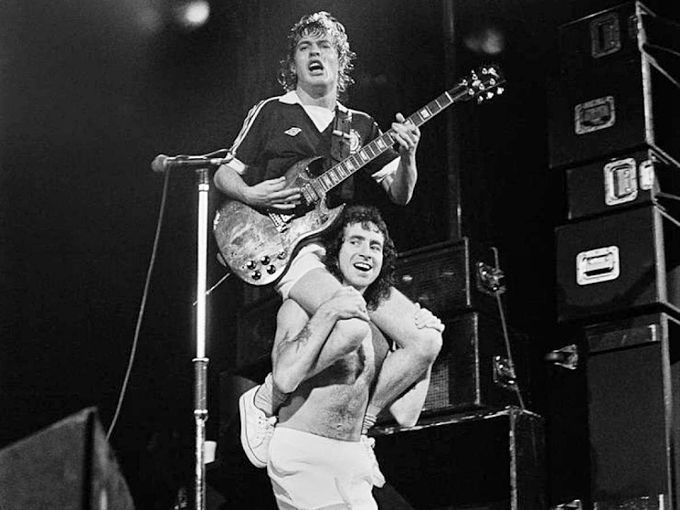 Angus Young riding on Bon Scott's shoulders at the Glasgow Apollo in Scotland in 1978. Photo by Fin Costello.