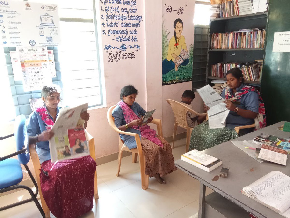 readingkafka's tweet photo. Self-help group waste management workers take some time to read the newspapers in the rural public library. There’s also a little kid reading in the corner. 🌷🌿📚🕊️#librariesforall #inclusivespaces https://t.co/VIFILJ5wA9