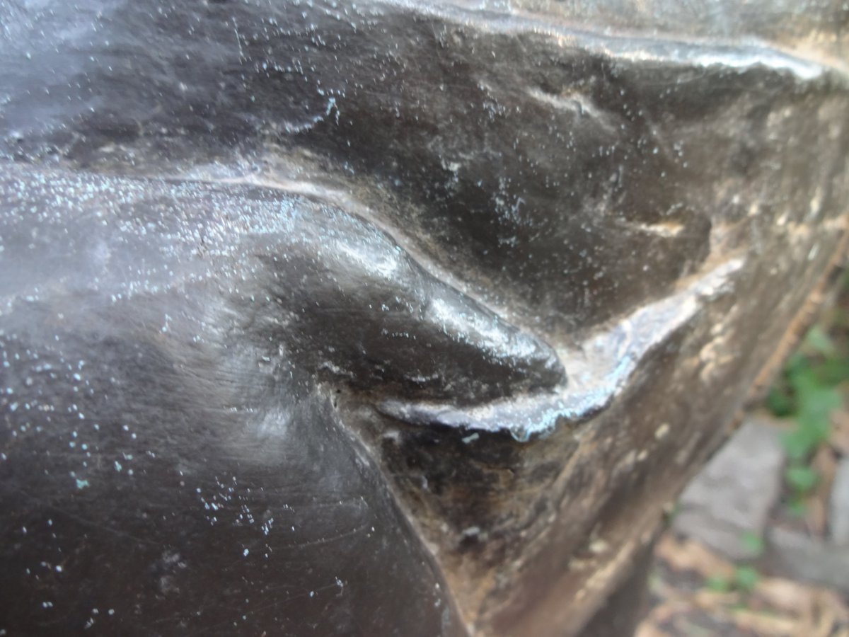 屋外に設置されたブロンズ製の彫刻のクローズアップ。中央にある突起