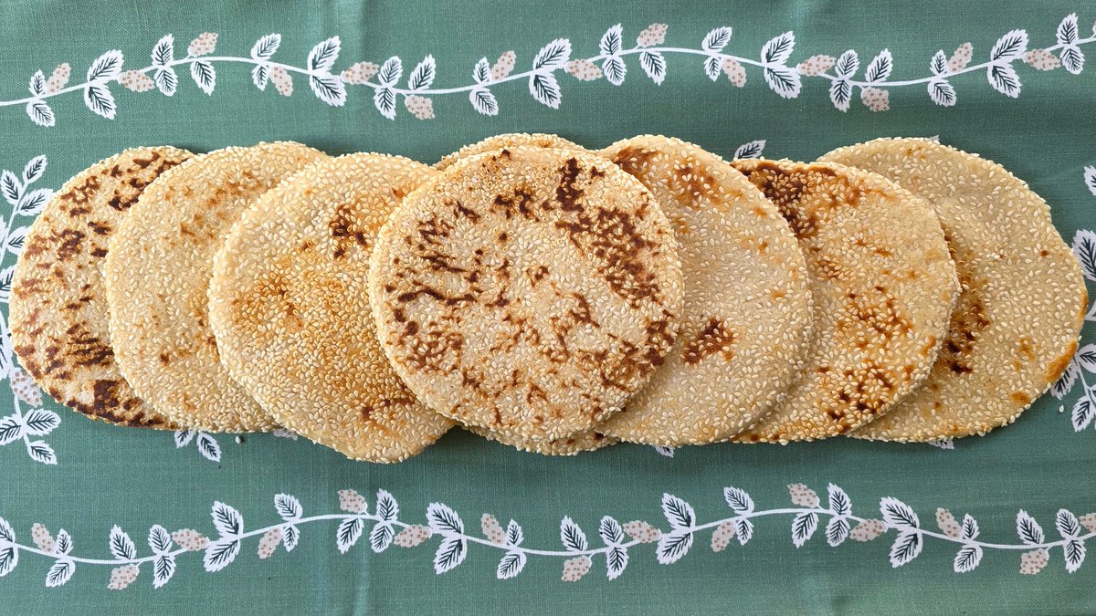 Sesame Flatbreads🌾No mess seeds stay on the bread because of an application technique from our Lebanese Purse Bread recipe. Dip the dough in honey-water, then in the seeds, and finally roll the dough into a circle, embedding the seeds into it. 
⁠Recipe: b7p.org/8i39w