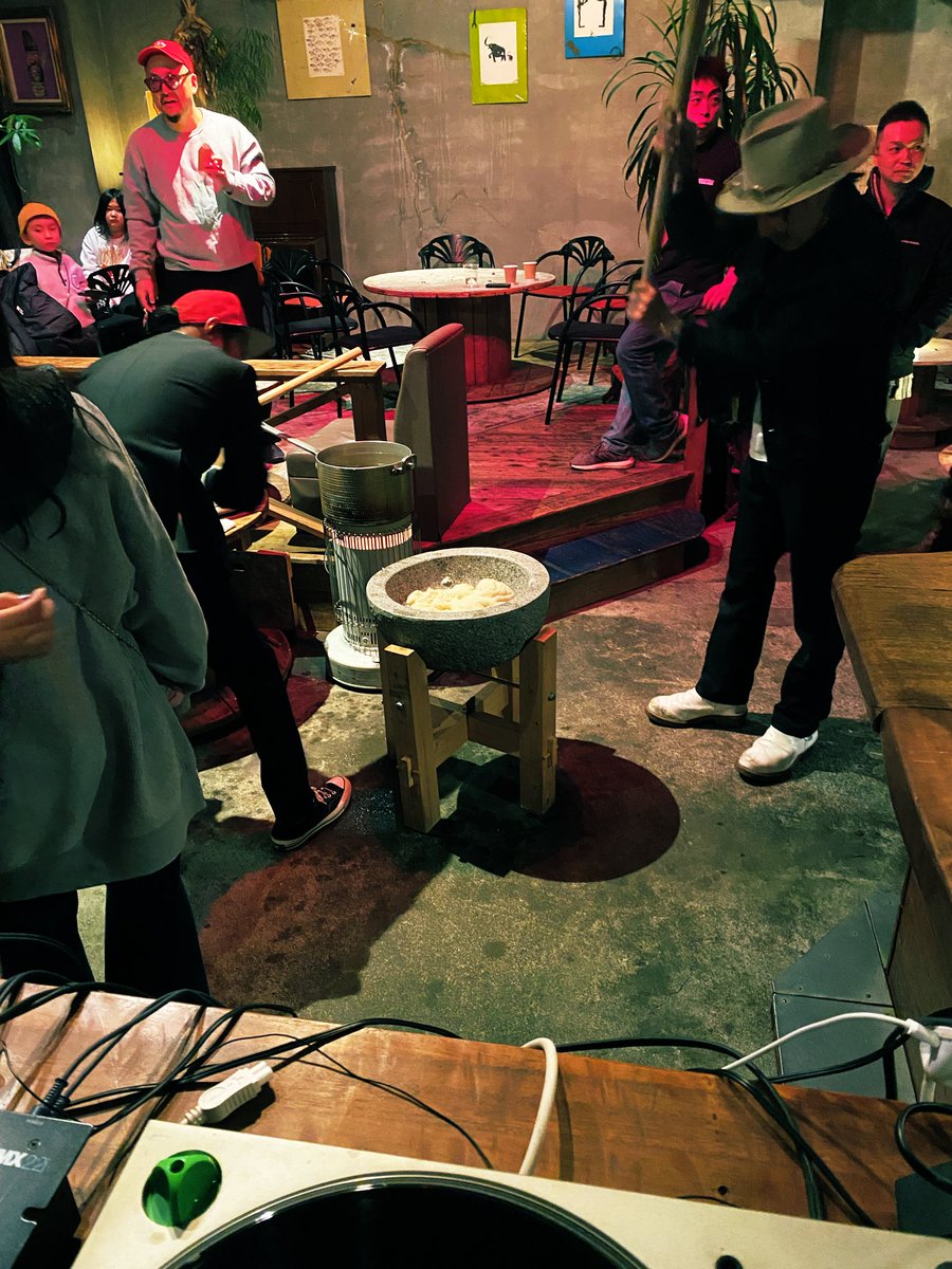 DJブース越しに餅つきの模様を眺めています