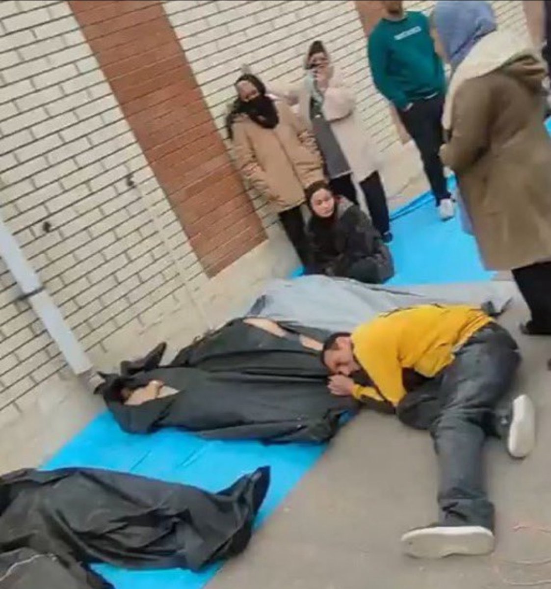 Iranian man crying next to the body of a family member murdered by the regime for protesting against the Islamic regime
