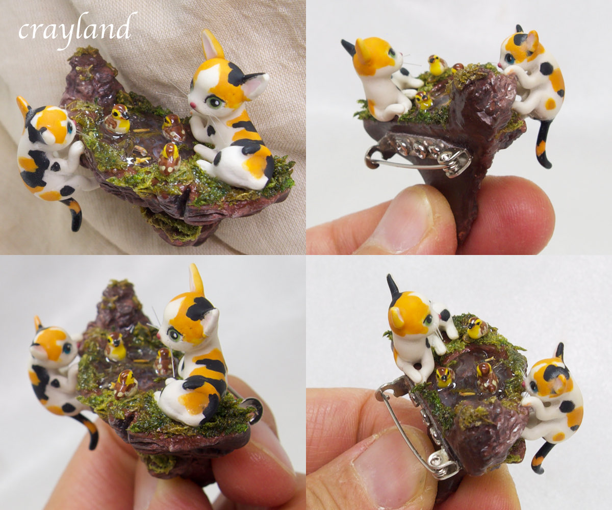 可愛い三毛猫ちゃんのブローチ作品が出来ました。崖の上の池で仲良く遊ぶ4羽のカルガモのヒナと2匹の三毛猫ちゃんのジオラマ風ブローチです。池の中を覗くと1mmくらいの小魚も泳いでいます。
#クレイアート　#粘土細工　#三毛猫
creema.jp/c/ysuna
minne.com/@nipring10