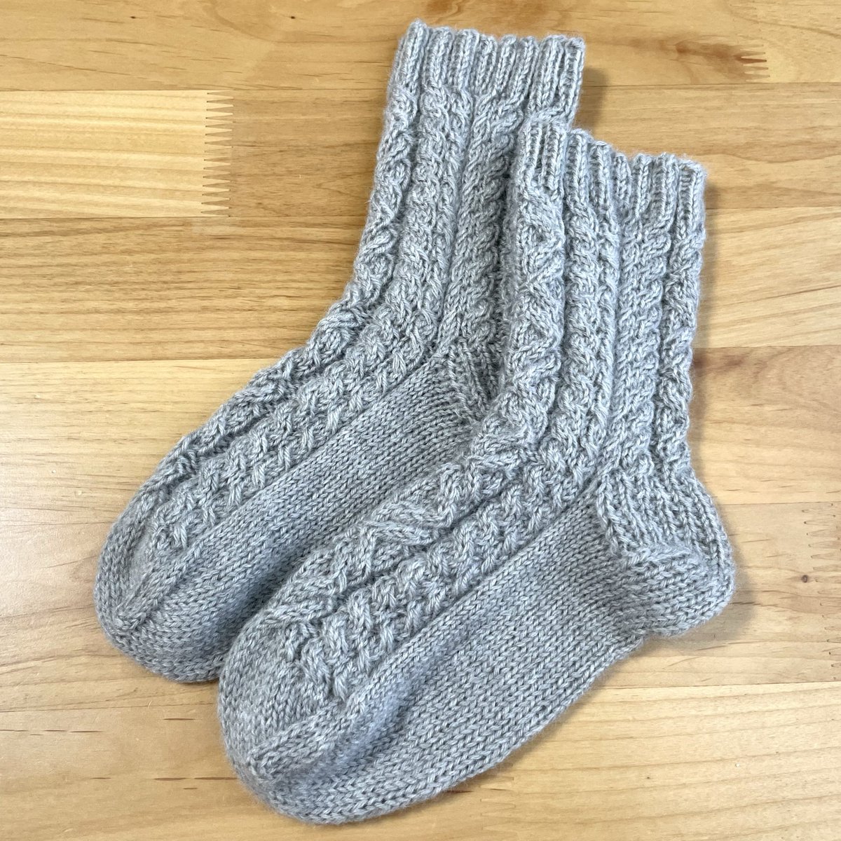 ami_note_'s tweet image. アラン模様の靴下編み終わった🧦

アメリーFで編んだのだけど、私めっちゃ上手になったんじゃない！？って勘違いしちゃうくらい綺麗に模様出てくれてびっくりした！

初めてまともに履けるのが編めた🫶

 #棒針編み
 #靴下
 #アラン模様