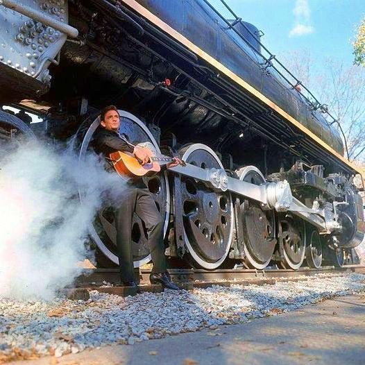 Johnny Cash in front of a locomotive. Photo by Michael Rougier.