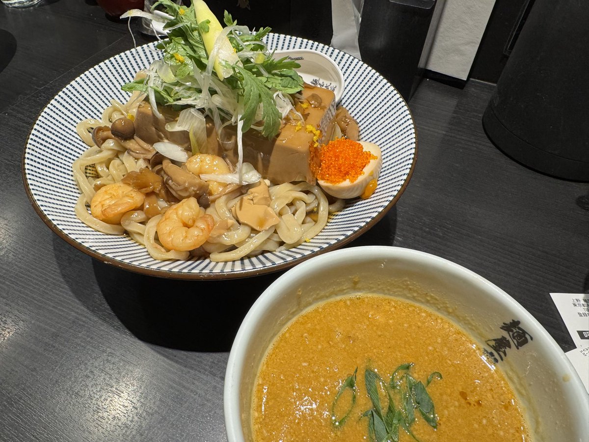 12月26日の麺屋武蔵 武骨相傳 <a href="/bukotusouden634/">麺屋武蔵 武骨相傳 公式</a> 
限定の海老味噌餡肝つけそば。海老がゴロゴロ入った餡掛け出汁が麺にかかり、その上には出汁を吸った豆腐。見た目も味もなかなか奇抜でかなりボリューミー。存在感も満足感も大きい。つけだれも濃厚で美味しく限定らしい攻めのある充実した一杯だった。