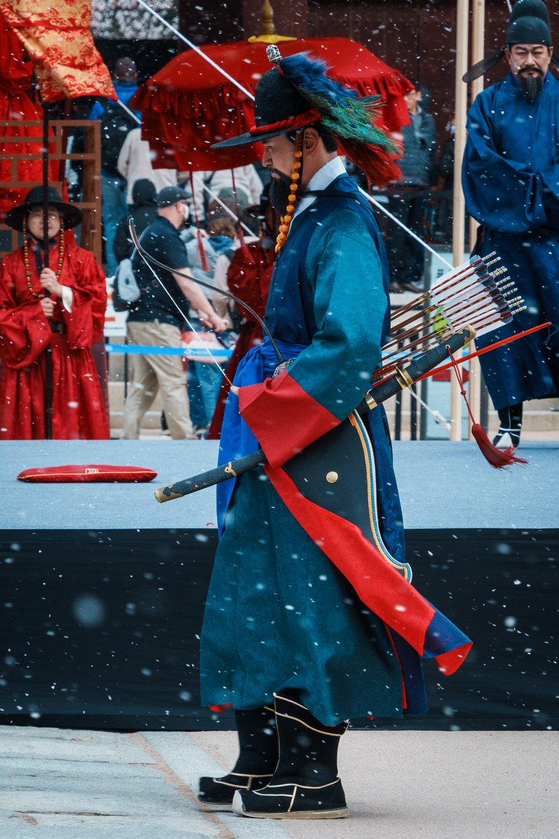 KHeritageAgency's tweet image. 바람에 휘날리는 옷자락🌬️
하얀 눈 속에서, 잠시 멈춘 듯한 시간
사극 엔딩 크레딧처럼 흘러가던 순간😌

❄️
❄️
❄️

눈이 내리는 궁궐 안에서
붉고 푸른 전통 의복을 입은 사람들이
아무 말 없이 자리를 지키고 서 있던 이 장면은
작년 3월 30일, 전국 수문장 임명의식의 한 순간입니다.