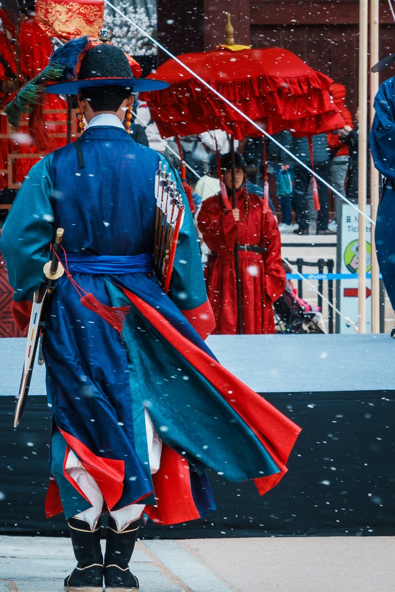 KHeritageAgency's tweet image. 바람에 휘날리는 옷자락🌬️
하얀 눈 속에서, 잠시 멈춘 듯한 시간
사극 엔딩 크레딧처럼 흘러가던 순간😌

❄️
❄️
❄️

눈이 내리는 궁궐 안에서
붉고 푸른 전통 의복을 입은 사람들이
아무 말 없이 자리를 지키고 서 있던 이 장면은
작년 3월 30일, 전국 수문장 임명의식의 한 순간입니다.