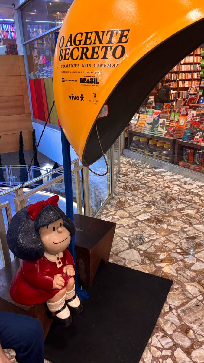 _renanguerra's tweet photo. amei que agora a Mafalda da Martins Fontes fica sentadinha do lado de um dos orelhões de “O Agente Secreto” ❤️ https://t.co/PfN6seh9hD