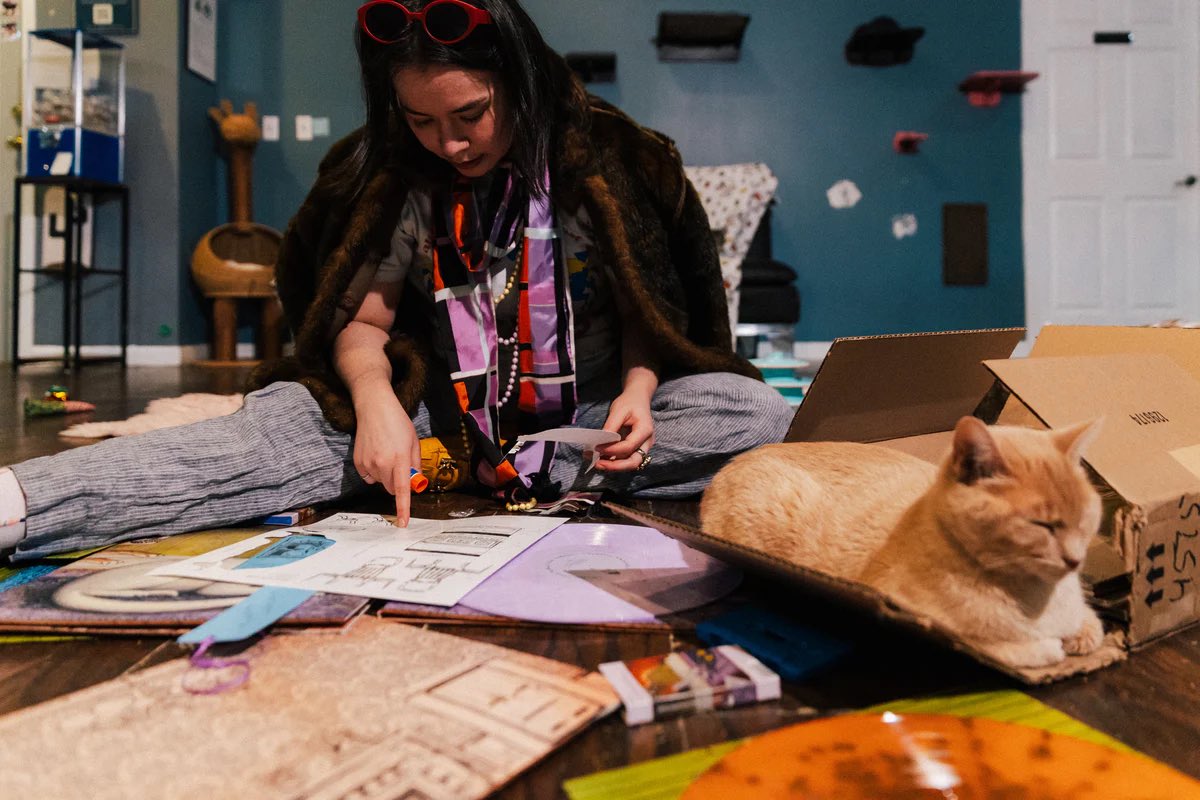 mitskipilledd's tweet image. Mitski posing for the 'Nothing's About to Happen to Me' deluxe lilac vinyl! 

the vinyl bundle includes a singed 12x12 album cover picture, a bookmark, lyric booklet, pop-out diorama and more!