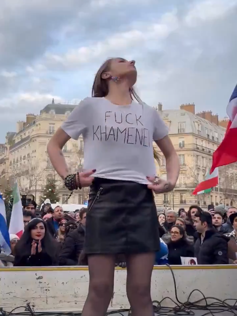 JulienPain's tweet image. Attention aux images qui circulent sur l'Iran. Par exemple celle-ci. Une vidéo qui montre une jeune femme enlever son voile et arborer un tee shirt "Fuck Khamenei". Elle a été tournée à Paris et il s'agit d'une militante du groupe d'extrême droite Eros.