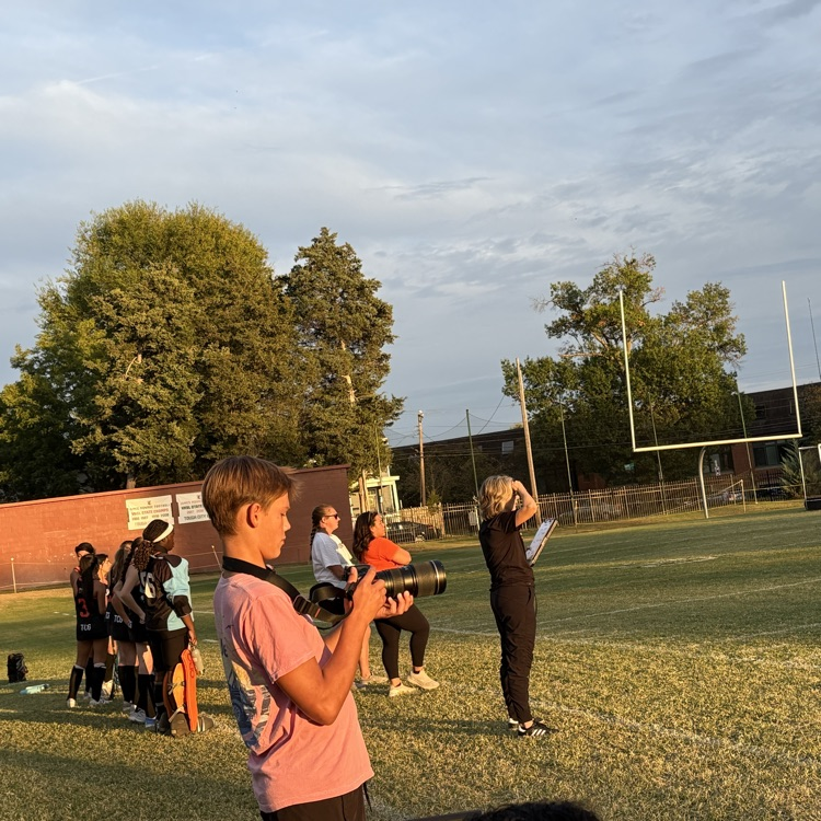 Focused and ready, Journalism student, Will Dickinson, frames the perfect shot to bring the field hockey game to life! 📸🏑