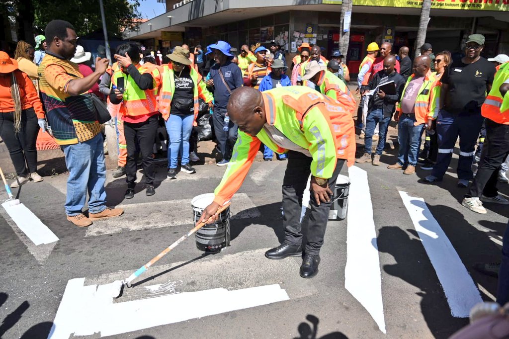 CityofJoburgZA's tweet photo. MMC for Group Corporate and Shared Services (GCSS), Cllr Sithembiso Zungu, joins Johannesburg Roads Agency (JRA) teams on the ground as they paint road markings on the asphalt.

#HighImpactServiceDelivery 
#JoburgReimagined ^GZ https://t.co/KG76dmNeux