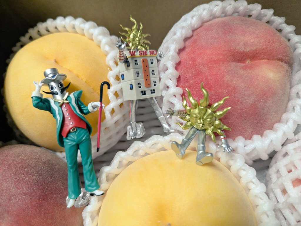 タローマンガチャ見つけたけど残りカプセルめっちゃ少ね〜〜って引いたら欲しいのほぼあって最高　背景は実家から届いた桃（地底の太陽とかも欲しかったが……）