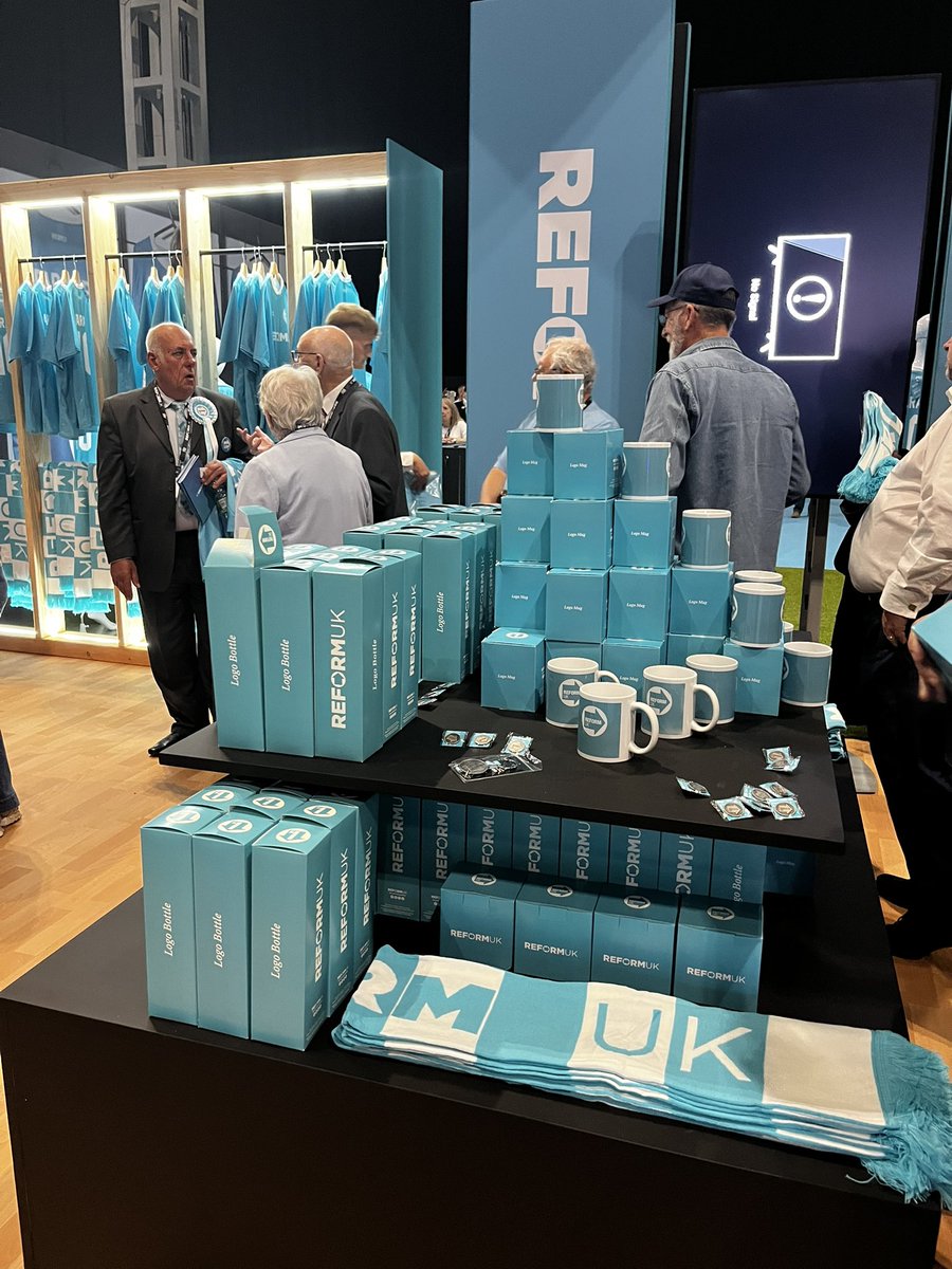 A queue for the <a href="/reformparty_uk/">Reform UK</a> merchandise stand ft. the sold-out Reform FC footie shirts
