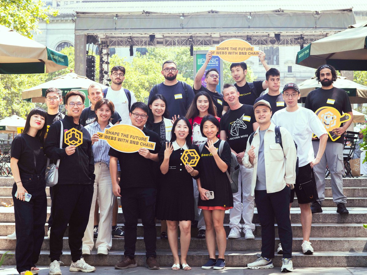 Group of BNB Chain enthusiasts holding signs at an outdoor event