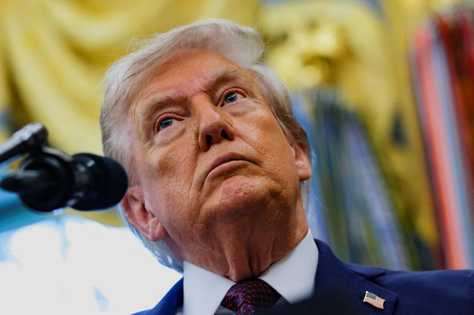 Donald Trump wearing a blue suit, red tie, and American flag pin, speaking at a podium with a microphone. A digital background with the Indian flag integrated into a circuit board design.