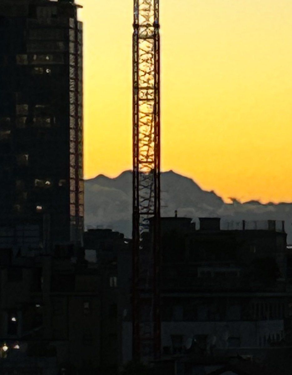 Dietro una gru, il Monte Rosa al tramonto. La mia #Milano
