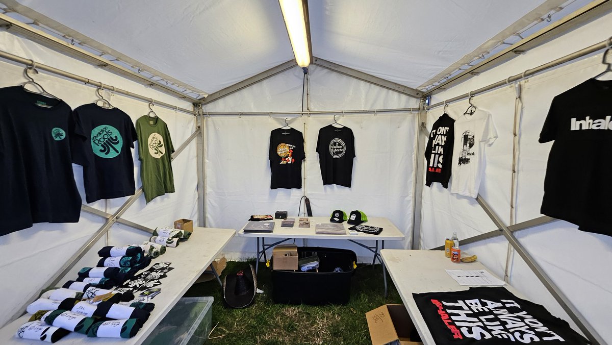 Merch tent, behind the sound stage 🕶️🔉🔊