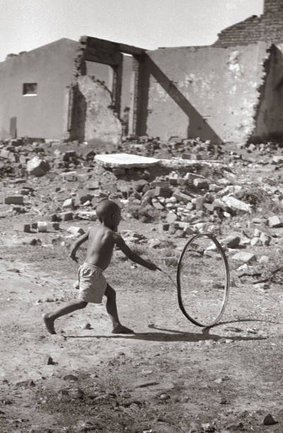 HistorySAZAR's tweet image. A little boy plays with a hoop and stick in Sophiatown, 1955. In 1955, the Group Areas Act allowed the government to relocate the black inhabitants of Sophiatown to the surrounding countryside, having allocated specific living areas to people of specific races. Picture: Jurgen…