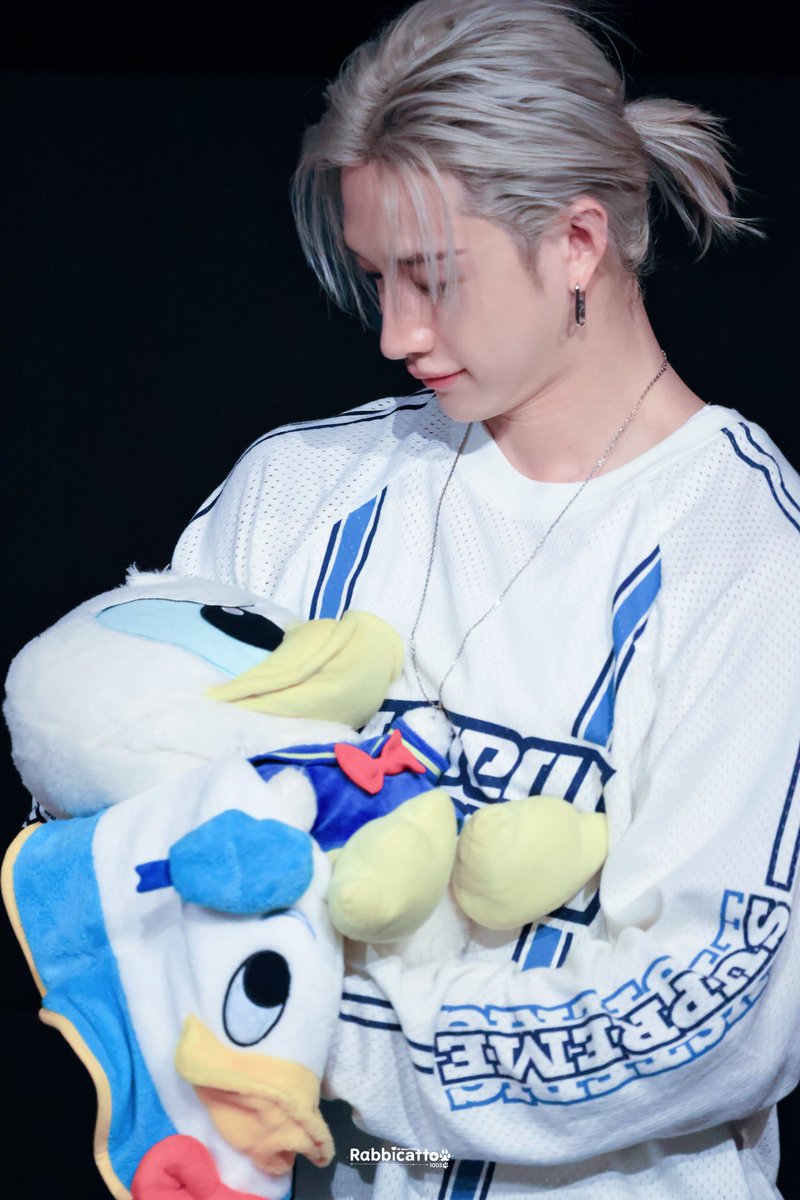 Bang Chan with a ponytail holding the donald duck plushie like a baby please i’m so devastated 😭😭😭😭