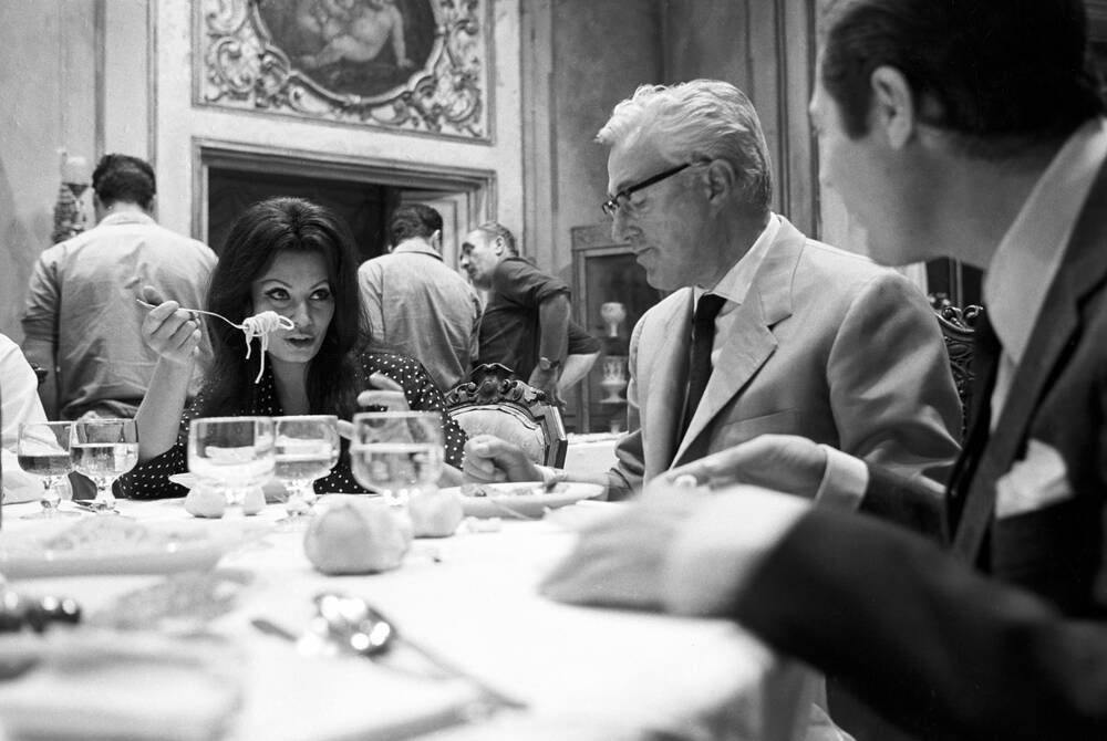 sophia loren eating spaghetti with vittorio de sica and marcello mastroianni, 1964.