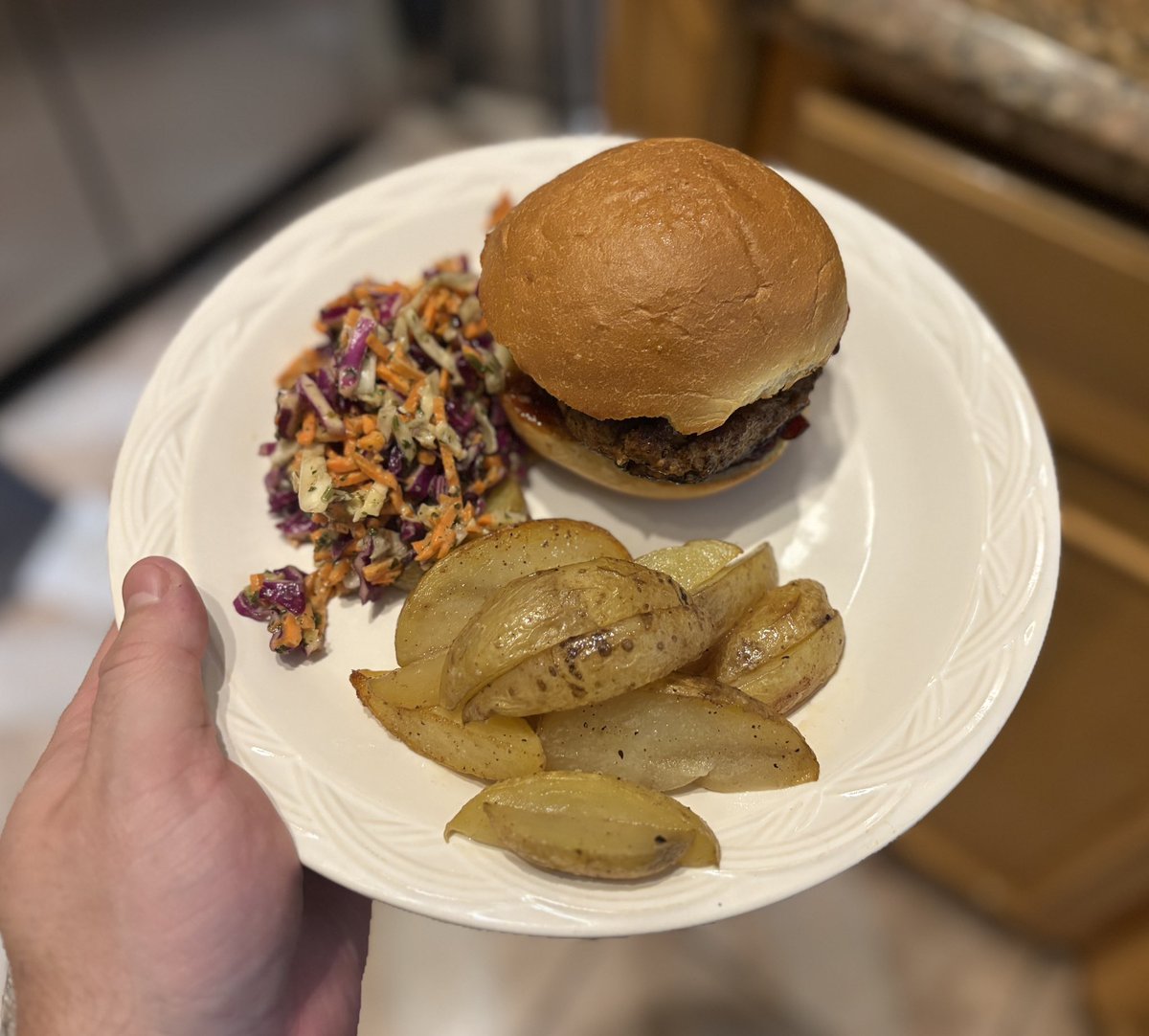Bbq turkey burger on a brioche bun with slaw and potato wedges