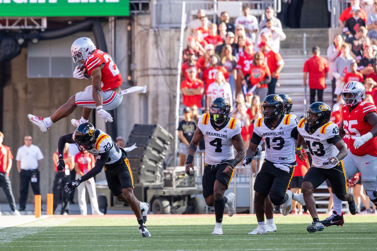 Ohio State running back James Peoples (20) hurdles over Grambling State defensive back Jalen Guillard (23) during the game Saturday at Ohio Stadium.