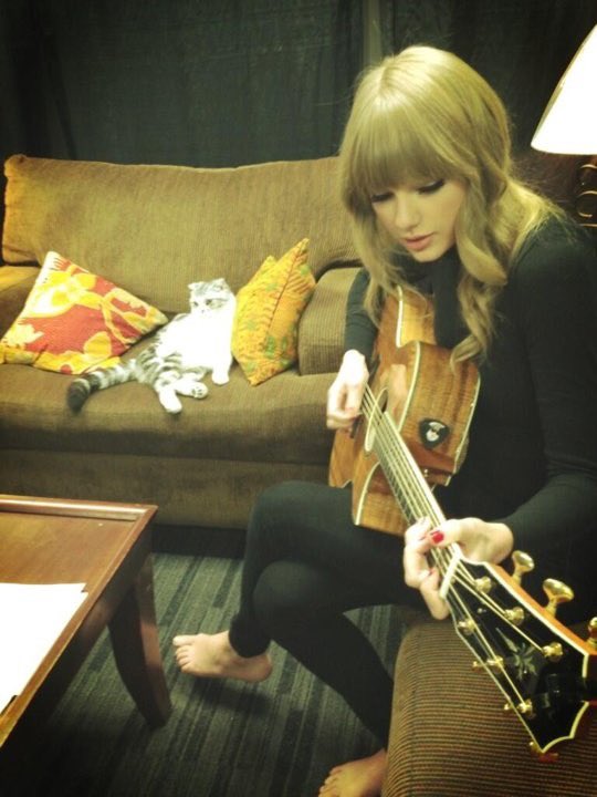 this is the most taylor picture ever she’s barefoot playing guitar for meredith
