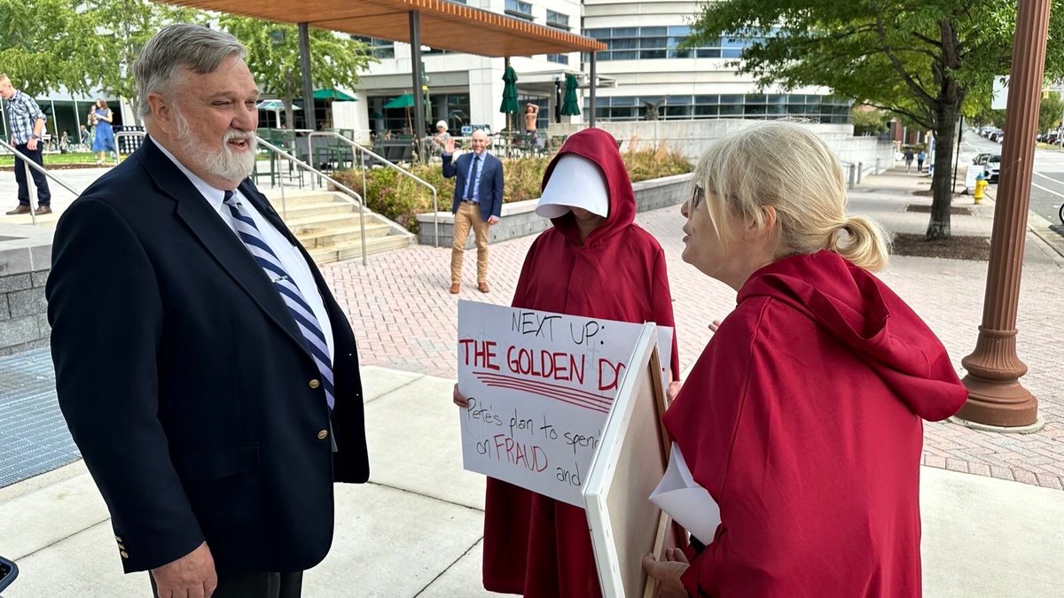joe_rigney's tweet photo. A DC resident sent me this photo he took outside of Christ Church DC this morning. Christian Nationalists talking to some Handmaids. Just another day in Donald Trump’s America. https://t.co/LLYAEQYKdB