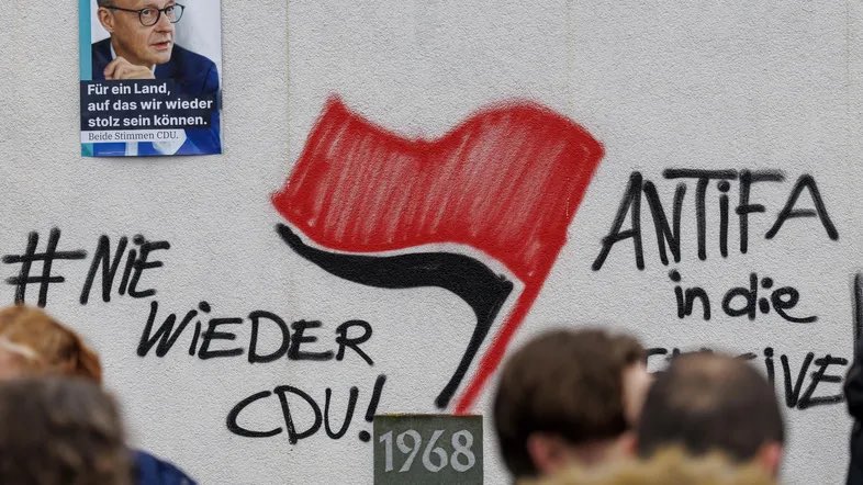 New: German police illegally raided the house of a minor SPD activist on suspicion of anti-Merz graffiti. 

The twist: Merz’s wife is the lead judge in the court that ordered the illegal search