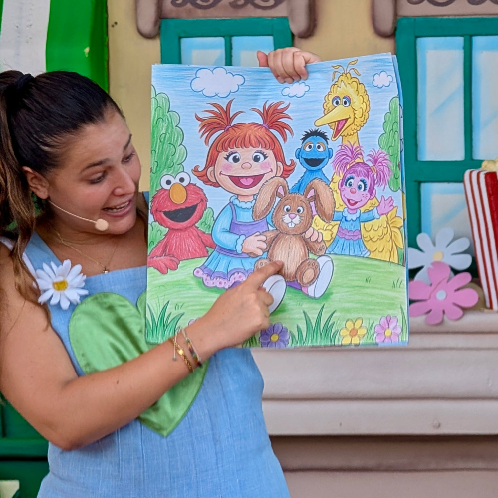 A Julia le encanta dibujar, y en este dibujo se ha retratado a sí misma junto a su conejo de peluche Fluffster y sus amigos de Barrio Sésamo