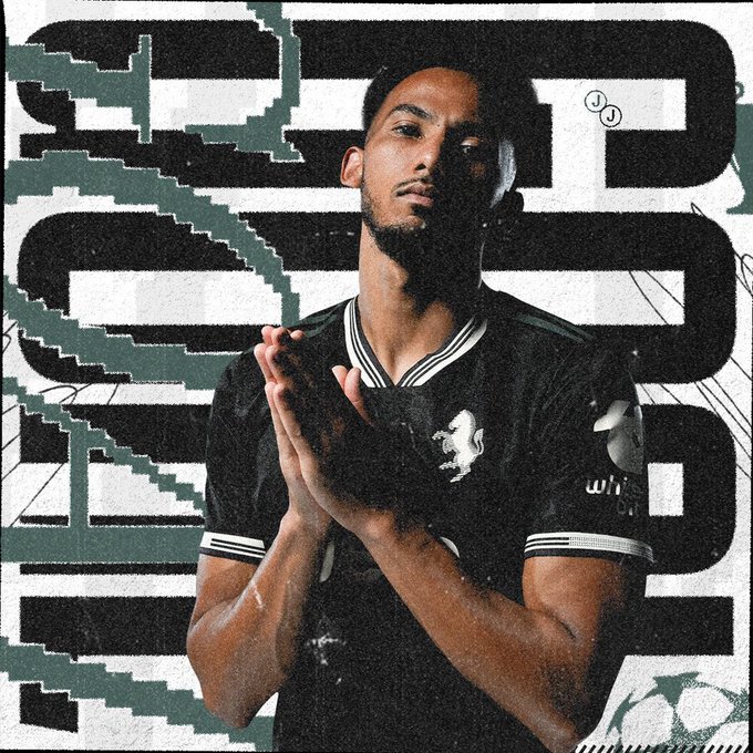 Kelly wearing a black Juventus soccer jersey with white stripes on the sleeves and a lion emblem. His hands are clasped together in front of his chest. Abstract black and white geometric patterns form the background.