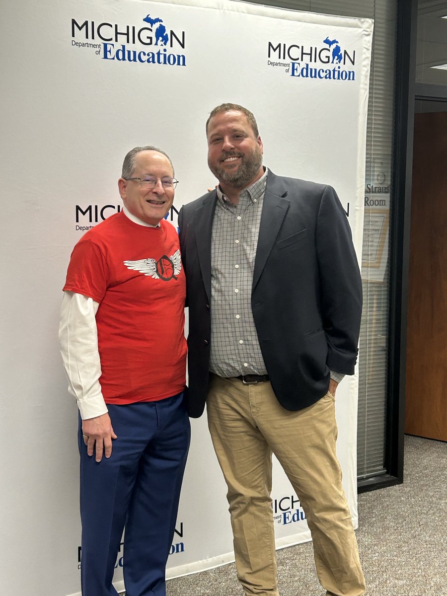 State Superintendent Dr. Michael F. Rice and #Michigan Teacher of the Year Corey Rosser from Quest High School take a photo before Rosser's State Board of Education presentation. Dr. Rice shows support for Quest High School by wearing the t-shirt given to him by Quest students.