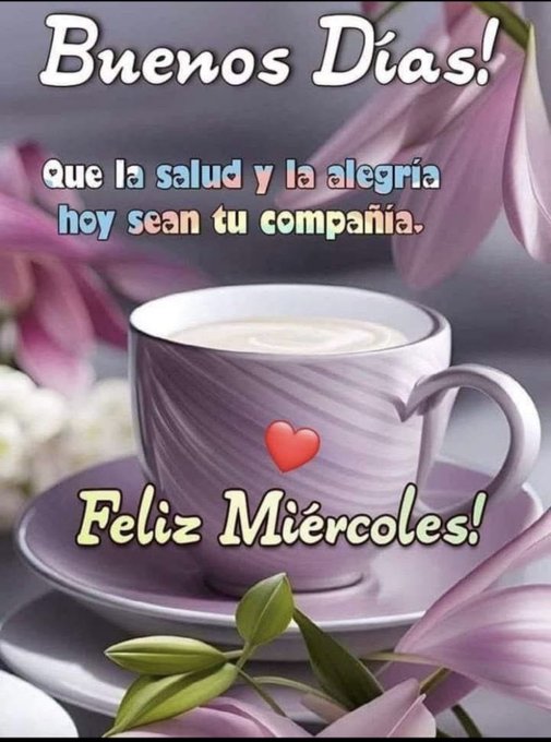A white ceramic cup with a purple swirl design, filled with coffee, sits on a matching saucer. Green leaves and pinkish-purple flowers are arranged around the cup. Text overlays read "Buenos Días!", "Que la salud y la alegría hoy sean tu compañía.", and "Feliz Miércoles!" with a small red heart near the cup.