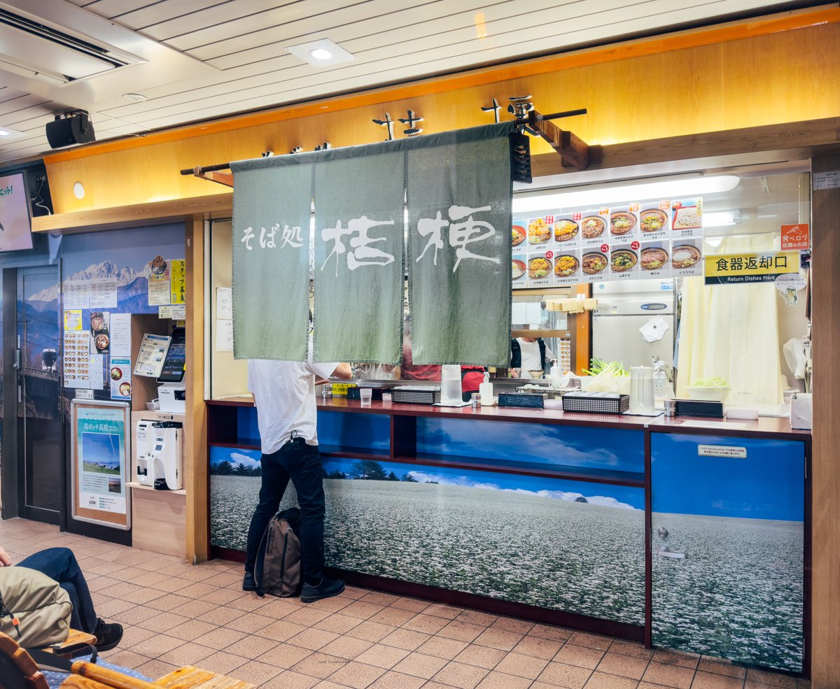 last_landscape's tweet photo. 塩尻駅の日本一狭い駅そば「そば処 桔梗」。実は改札内外どちらにも立ち食いスペースがあるが、改札内側は滞在人数2名が限界。日本が誇る蕎麦の本場・長野県は蕎麦屋の店舗数も日本一と言われている。駅で食べると一段と美味しく感じるのは不思議なもの。#塩尻市 https://t.co/04WndyPfYi