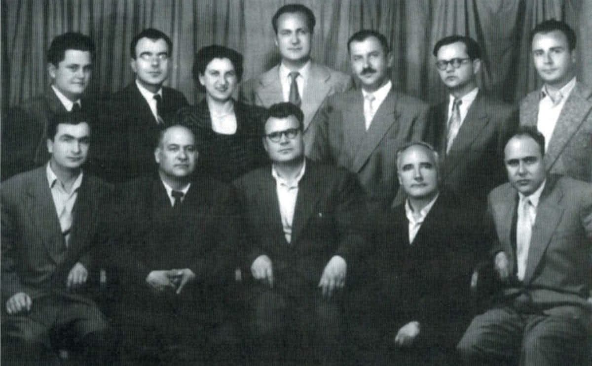 Вонвременска слика на 
Македонските великани.

Од лево кон десно, седат: 
Ацо Шопов, Антон Панов, Ѓорѓи Абаџиев, Васил Иљоски и Димитар Митрев.

стојат: 
Александар Спасов, Јордан Леов, Лина Малинска, Јован Бошковски, Коле Чашуле, Блаже Конески и Симон Дракул.